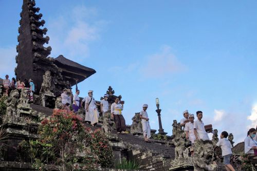 Free People in traditional attire at the iconic Besakih Temple in Bali, Indonesia, during a cultural ceremony. Stock Photo