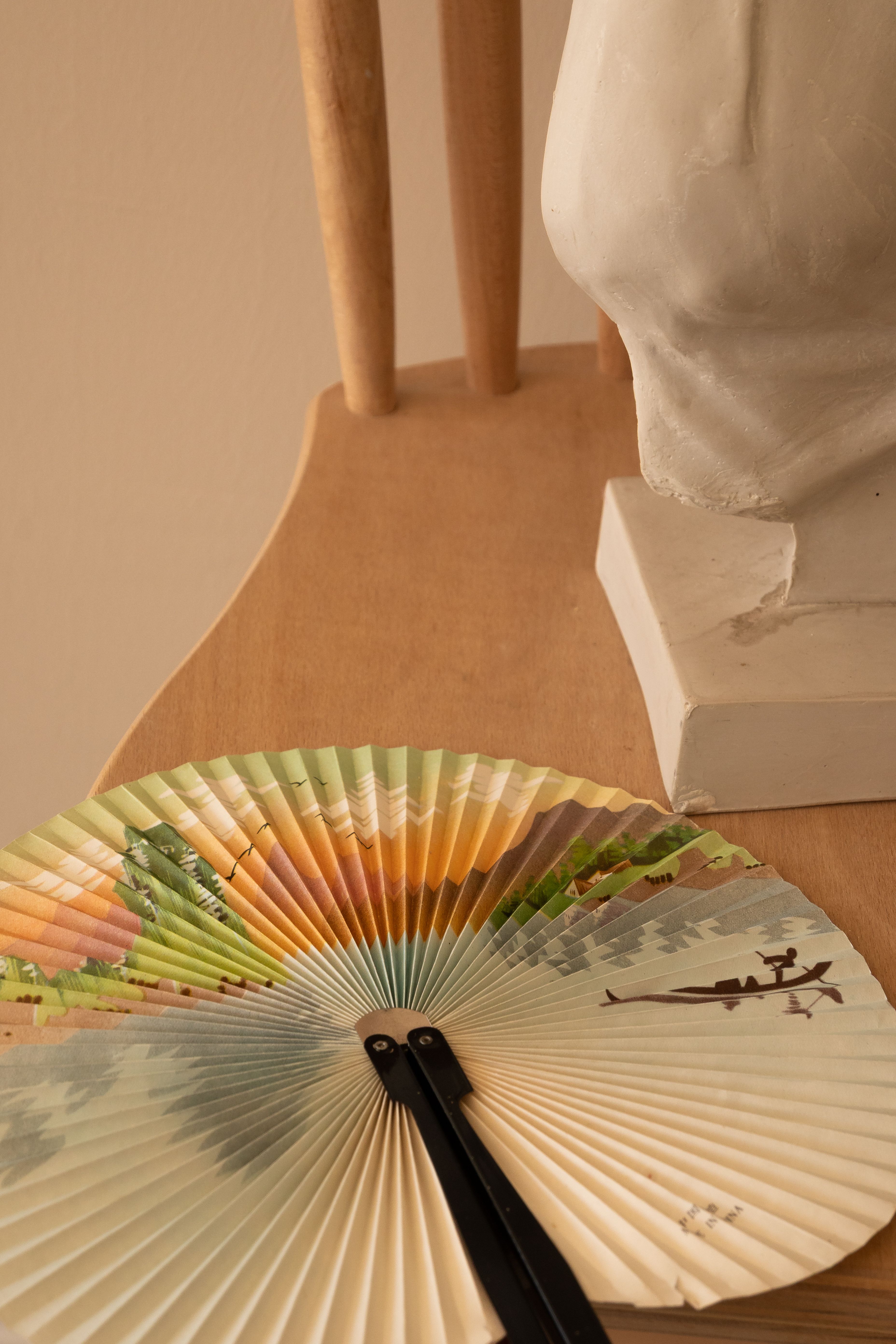 Elegant Still Life of Fan and Sculpture on Chair · Free Stock Photo