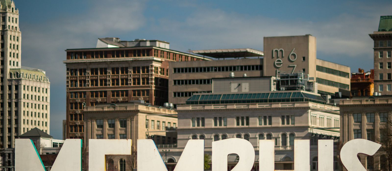 View of the Memphis sign set against the historic city skyline, showcasing iconic architecture.