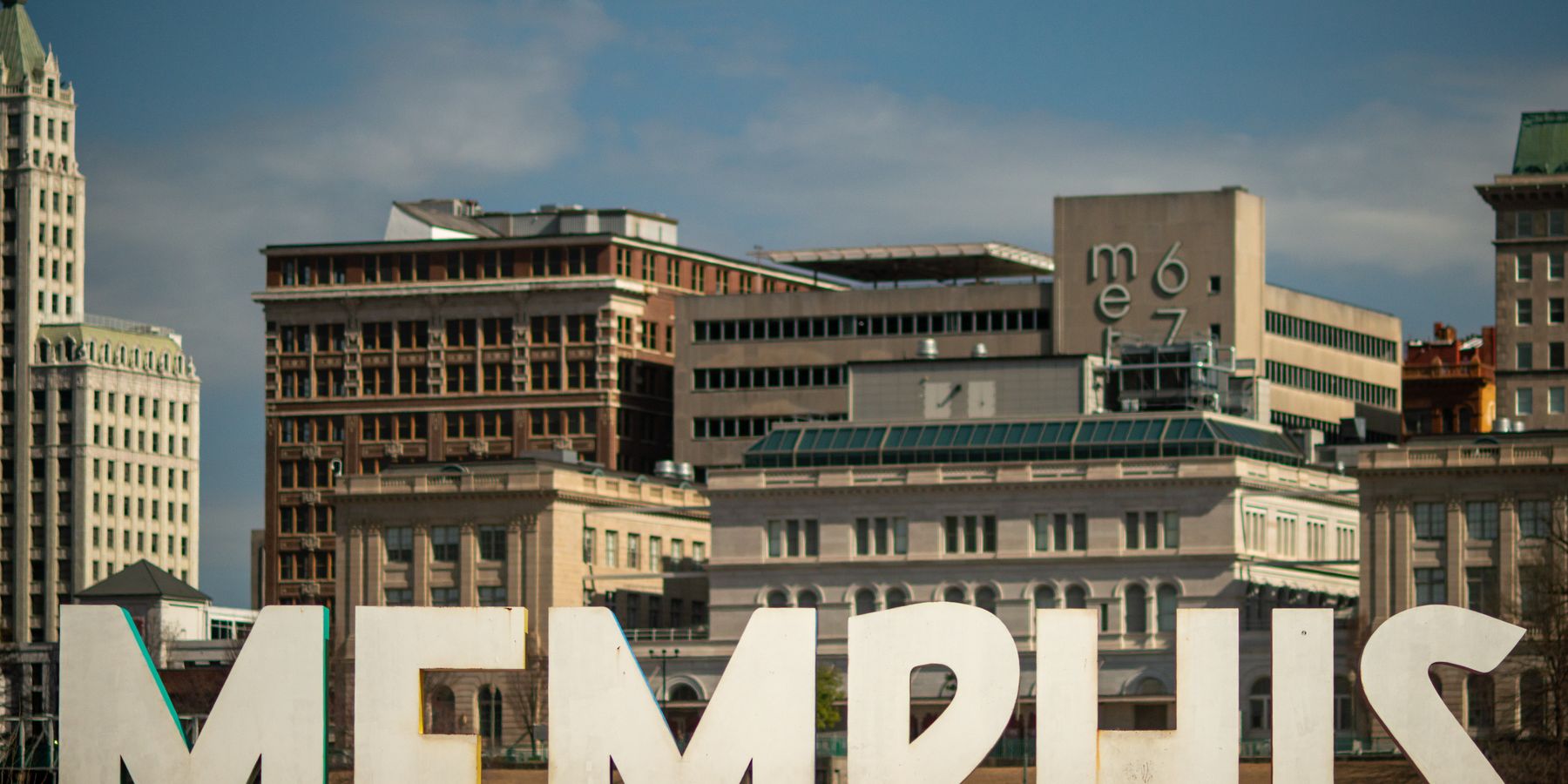 View of the Memphis sign set against the historic city skyline, showcasing iconic architecture.