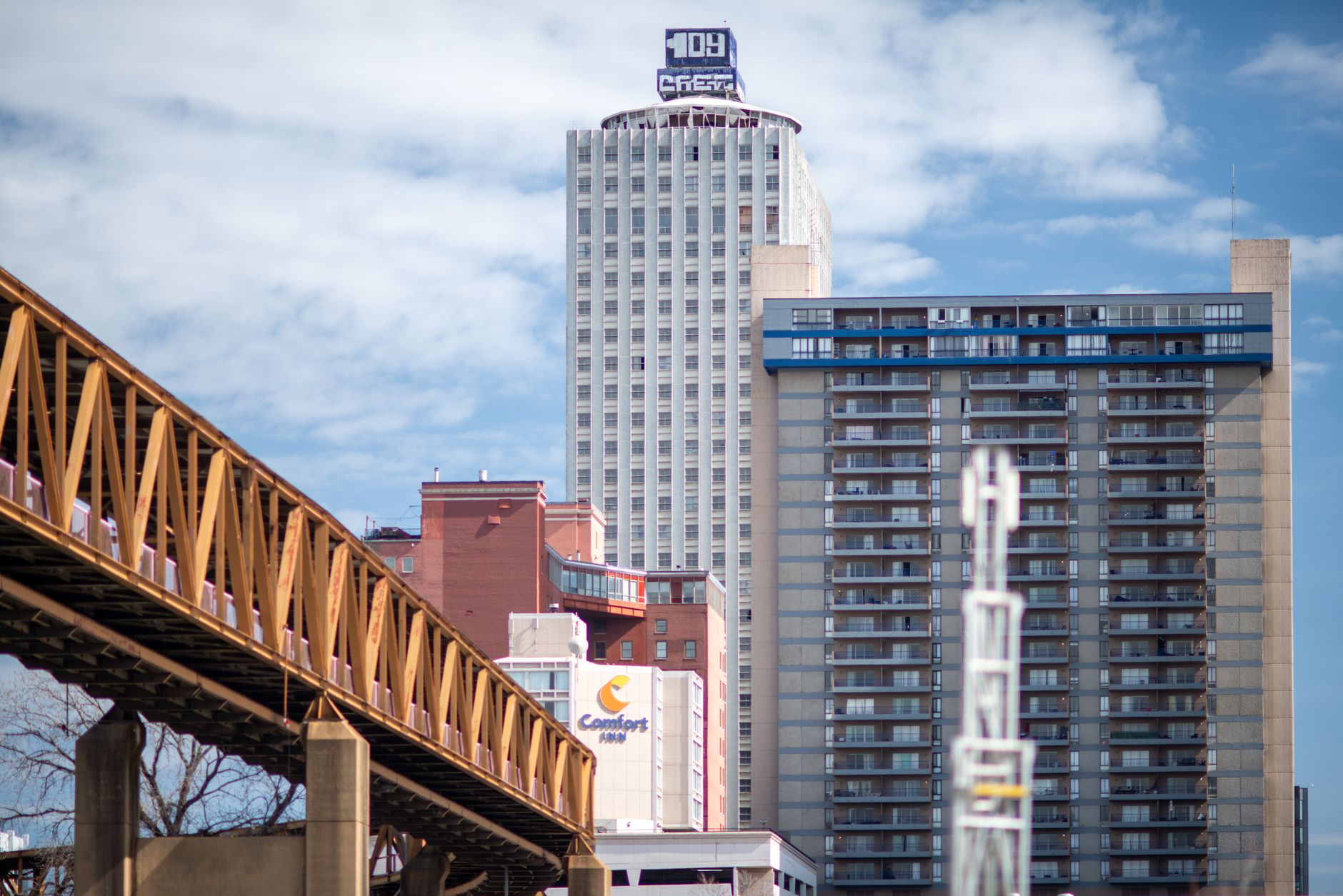 Skyline view capturing bridges and buildings in downtown Memphis, Tennessee under a bright sky.