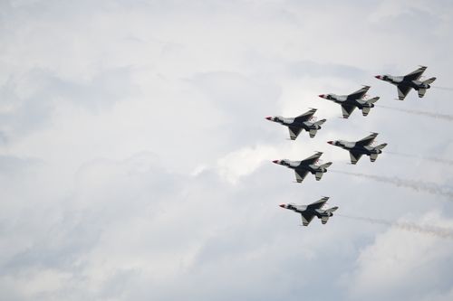 Free A striking view of fighter jets flying in formation against a clouded sky. Stock Photo