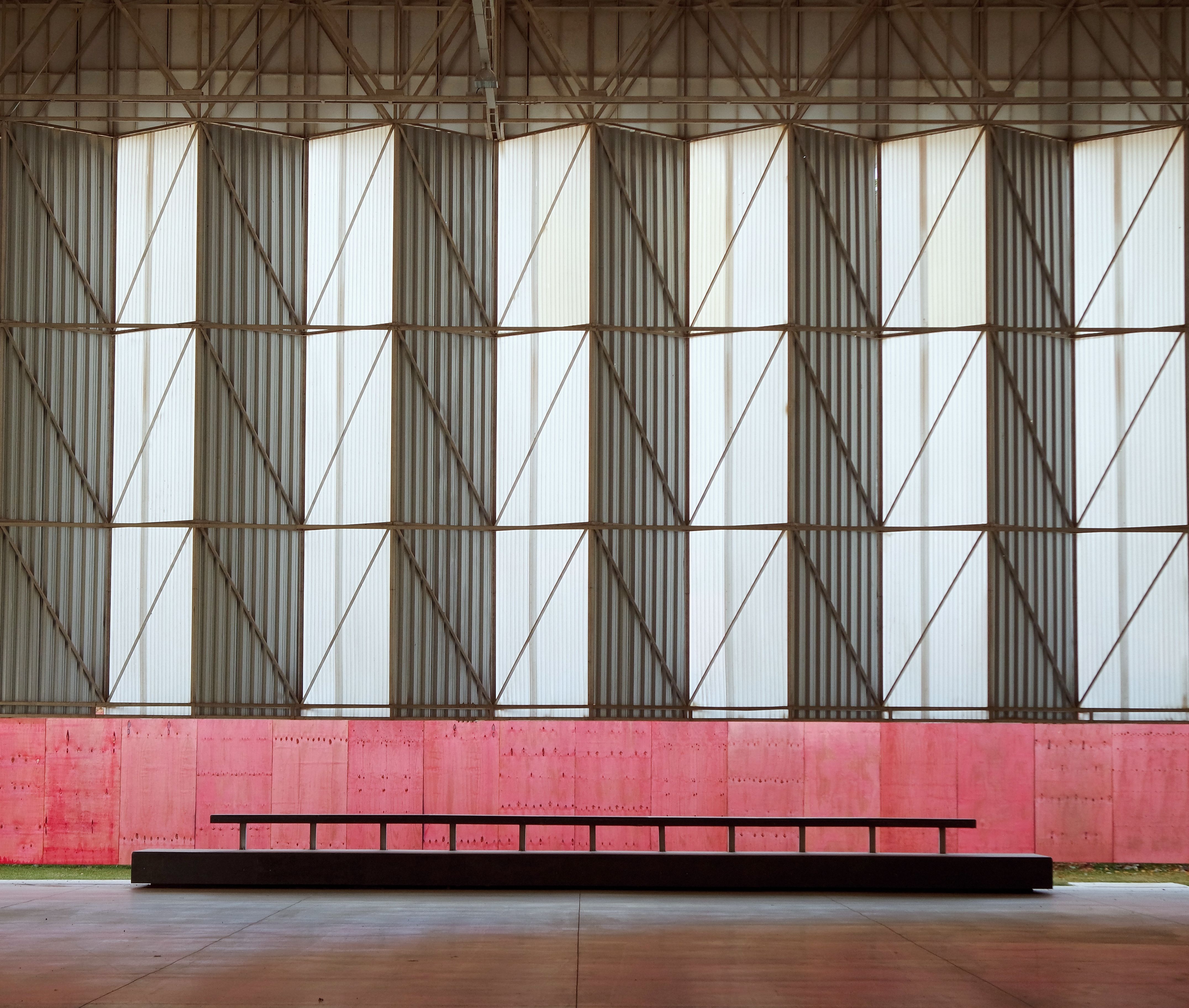 Geometric wall design with metal and red panels in an industrial setting in Viçosa, Brazil.