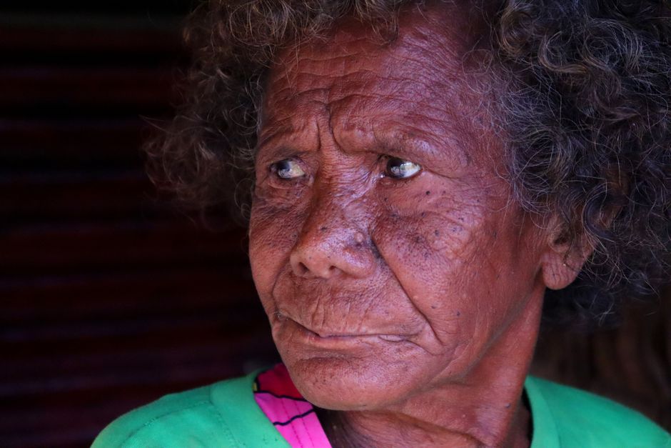 Close-up portrait of an elderly person with expressive eyes in natural lighting.