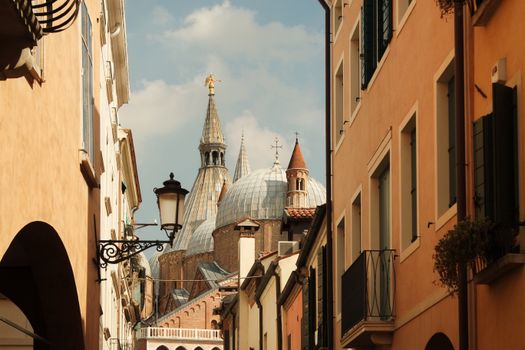Dome and spires of Basilica di Sant'Antonio from a charming street in Pádua, Italy.