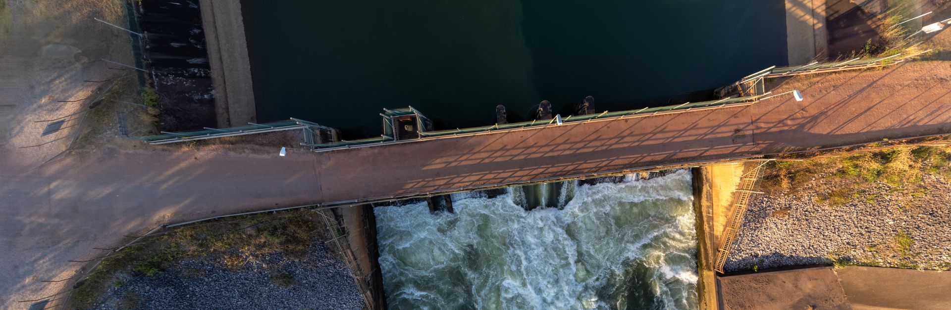 Aerial shot of a hydroelectric dam in Laos, capturing water flow and infrastructure.