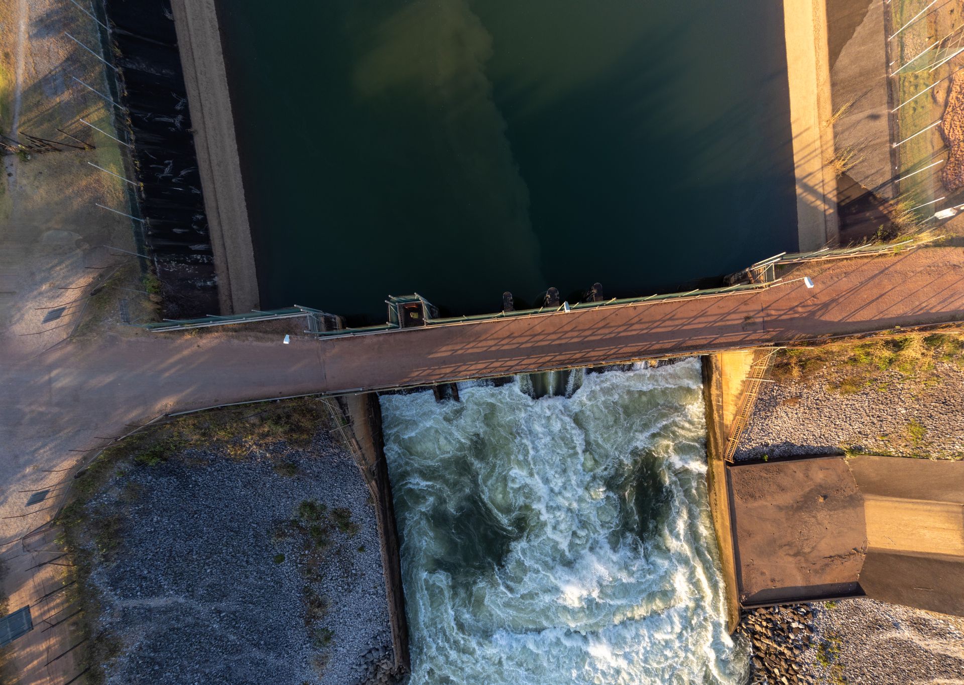 Aerial shot of a hydroelectric dam in Laos, capturing water flow and infrastructure.