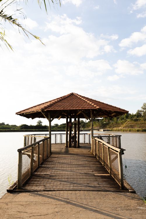 Free Charming wooden gazebo on a pier over a tranquil lake with blue sky at São Paulo, Brazil. Stock Photo