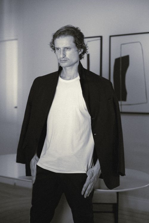 Free Black and white artistic portrait of a stylish man in a modern indoor setting. Stock Photo