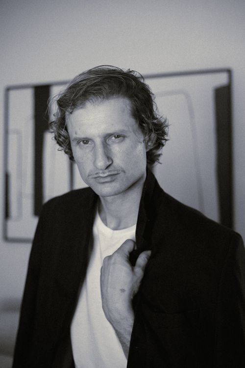 Free Expressive black and white portrait of a man wearing a suit jacket indoors, creating a vintage mood. Stock Photo