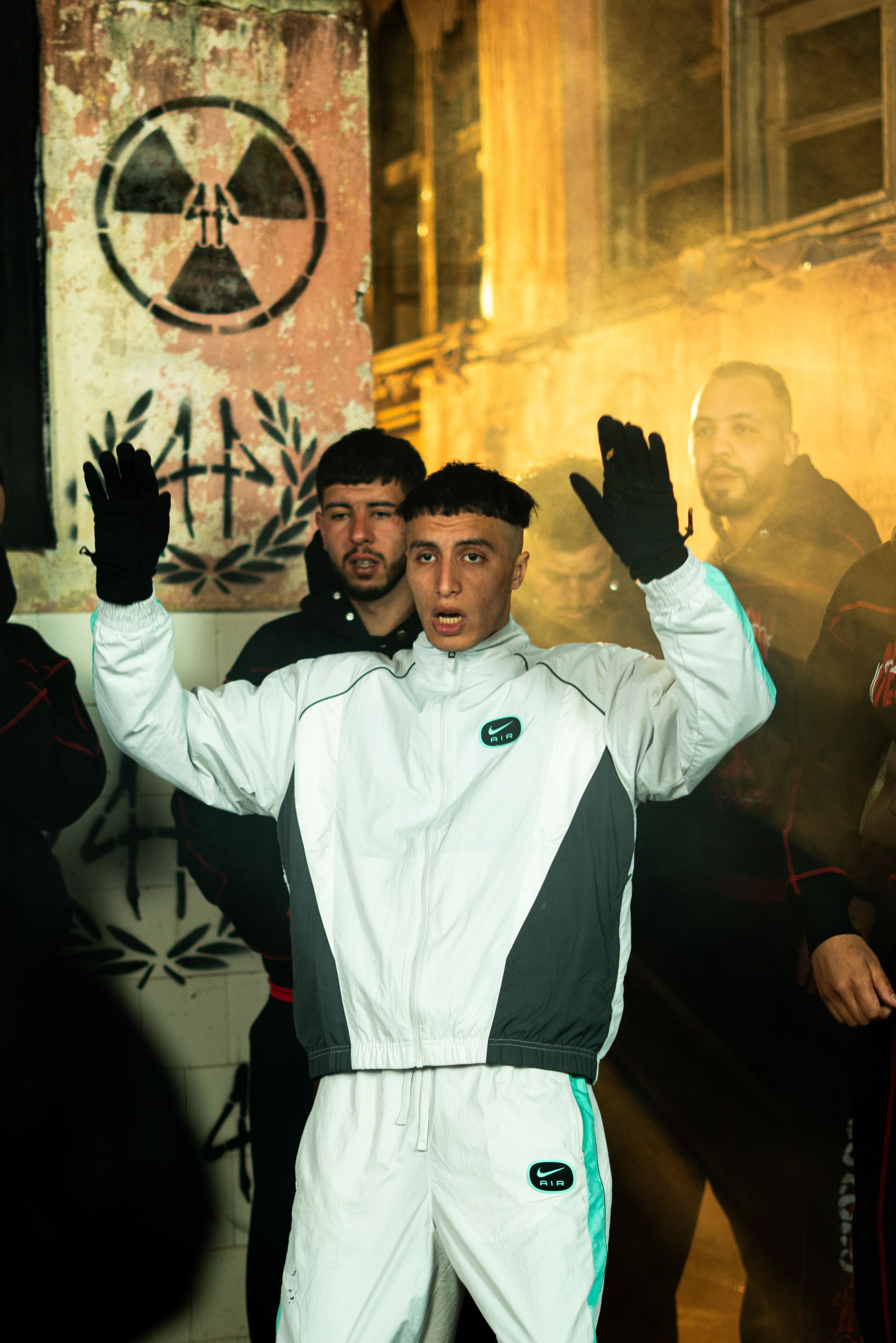 A group of young adults in urban attire gather in a gritty, industrial setting in Morocco.