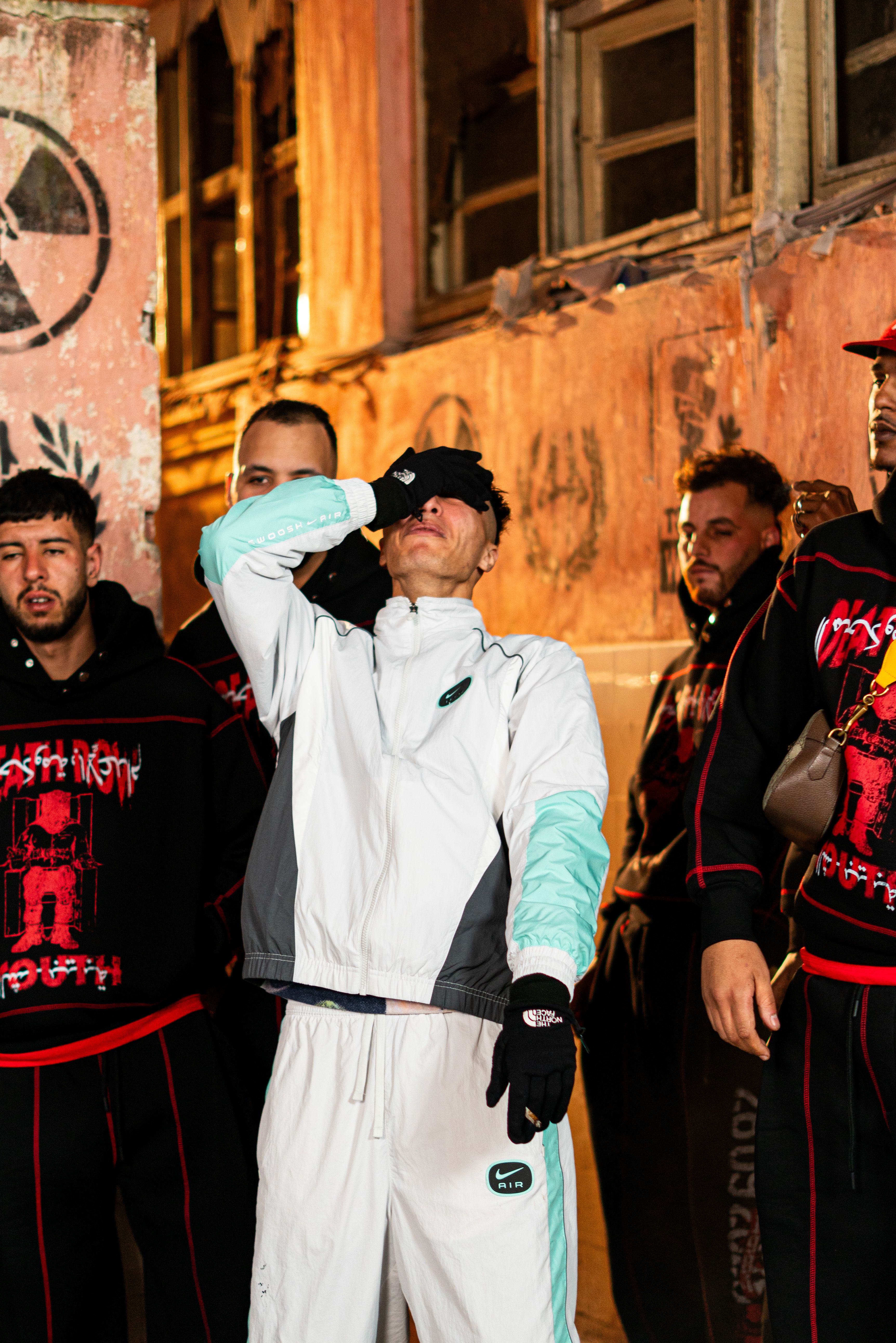 Streetwear fashion in an urban Moroccan setting with a group of men at night.