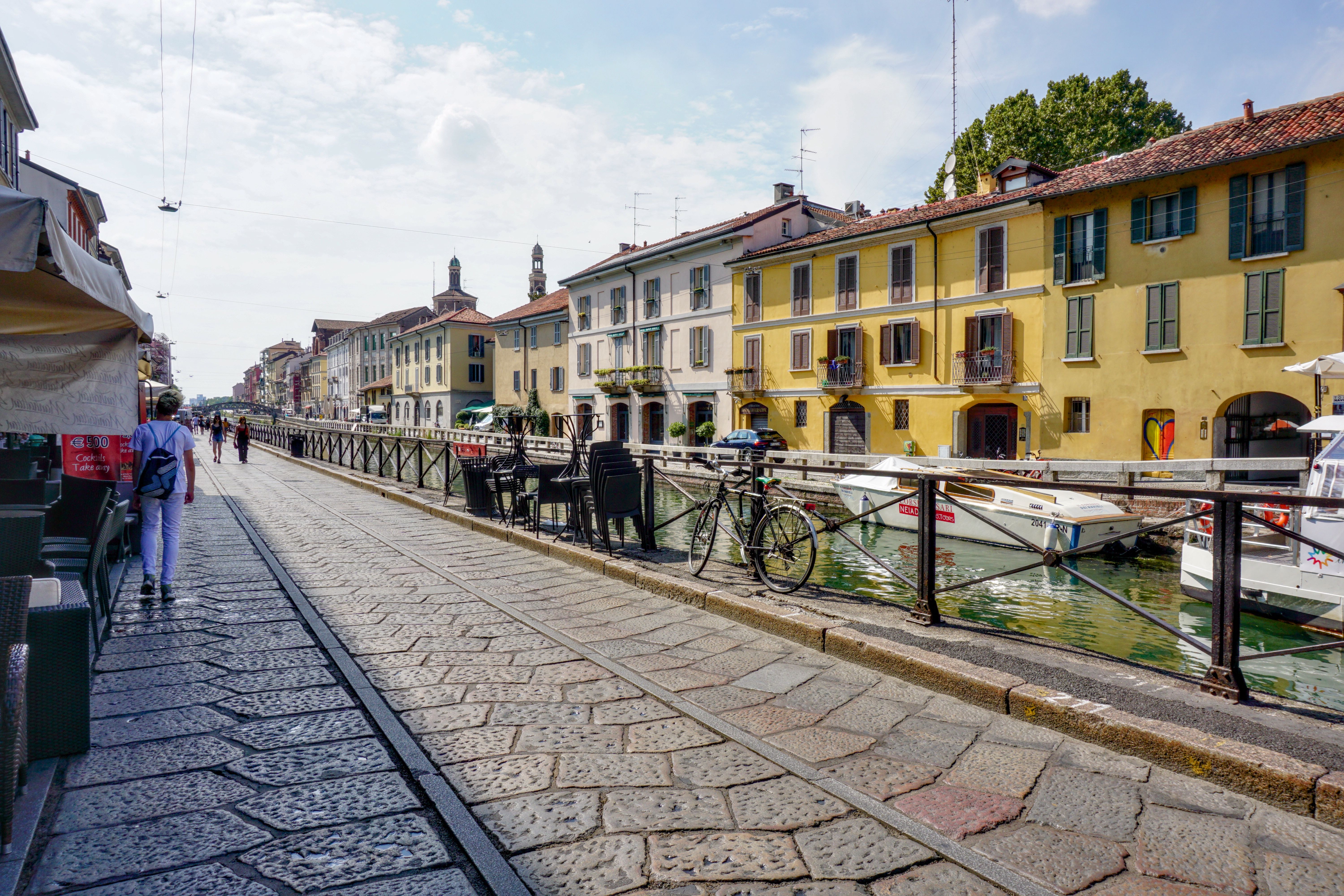Vibrant canal-side street in Milan, showcasing colorful historic buildings and a serene atmosphere.