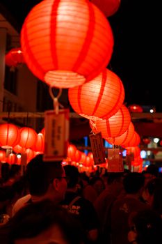 A bustling night market scene with red lanterns illuminating the night sky, symbolizing celebration and tradition.