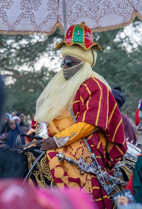 Free Colorful traditional African horseman in ceremonial attire during a festive event outdoors. Stock Photo