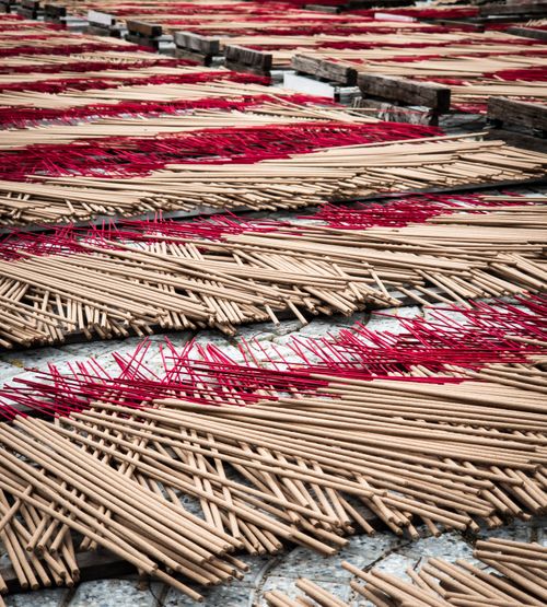 Free Rows of brown and red incense sticks drying in the sun, creating a vibrant pattern. Stock Photo