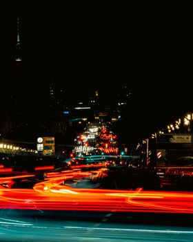 Long exposure of bright light trails against a dark Berlin night, highlighting dynamic urban life.