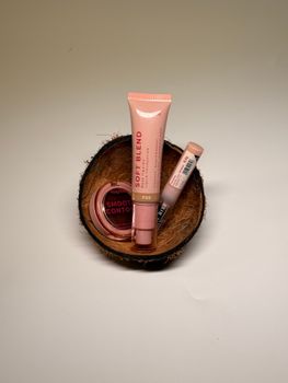 Assorted beauty products in a coconut shell, highlighting natural skincare. Ideal for tropical-themed settings.