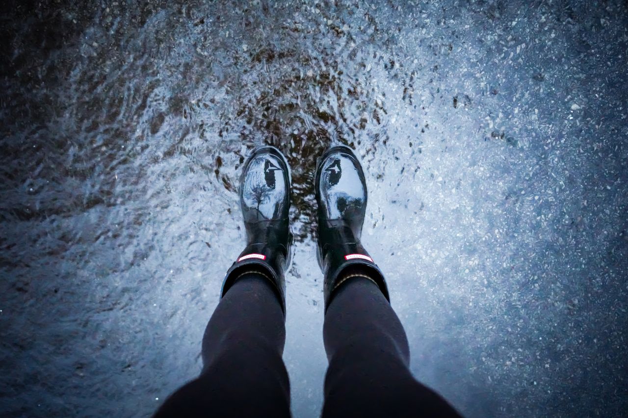 black rain boots standing in a puddle