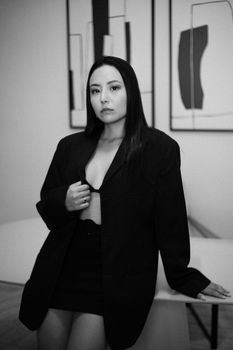 Stylish black and white portrait of a woman in a blazer, exuding confidence and elegance.