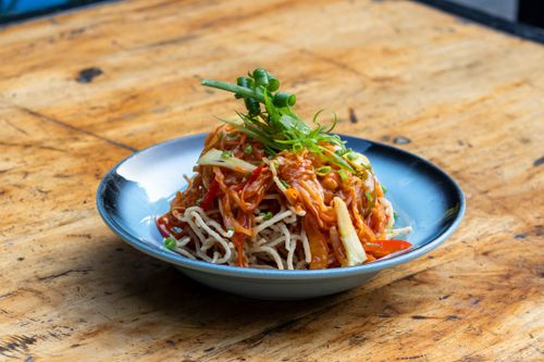 Free A vibrant Asian noodle salad topped with fresh vegetables, perfect for a healthy meal. Stock Photo