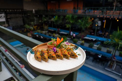 Free A vibrant vegetarian dish presented on a balcony, overlooking a lively outdoor setting. Stock Photo