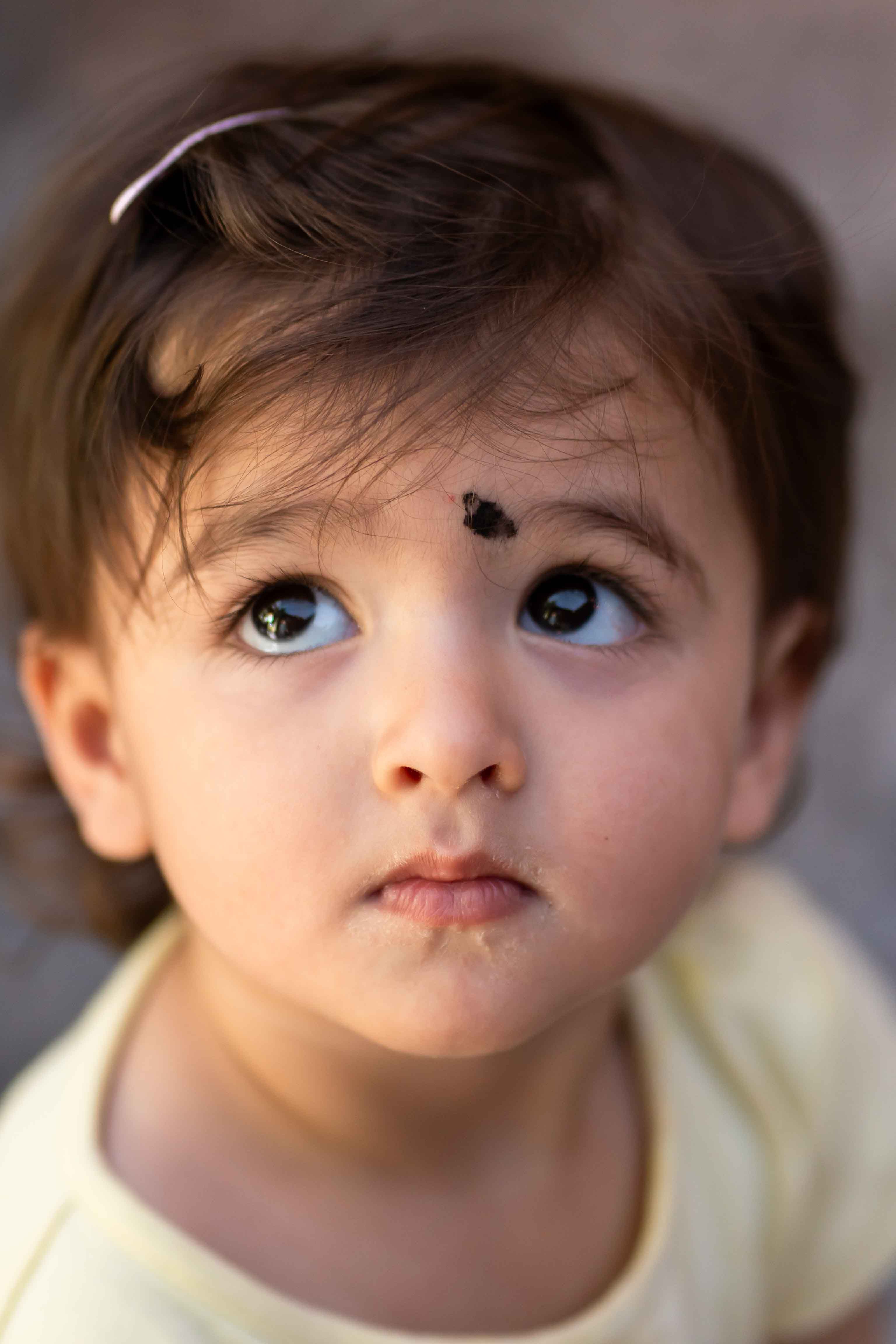 Charming portrait of a young child looking up with wonder in natural light.