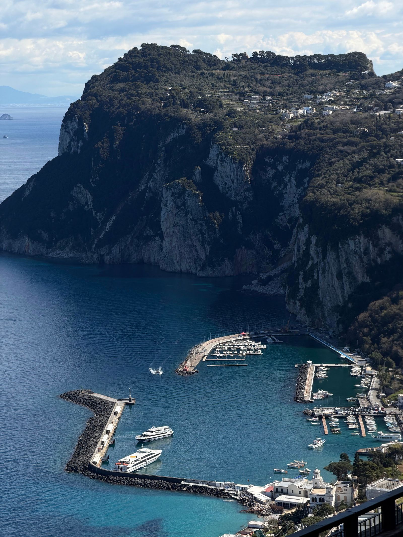 Aerial view of Capri's Marina Grande harbor with boats and colorful waterfront buildings