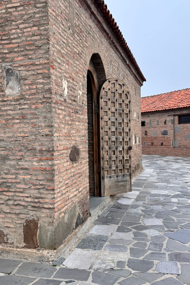 An old stone building with a traditional wooden door in a historic location.