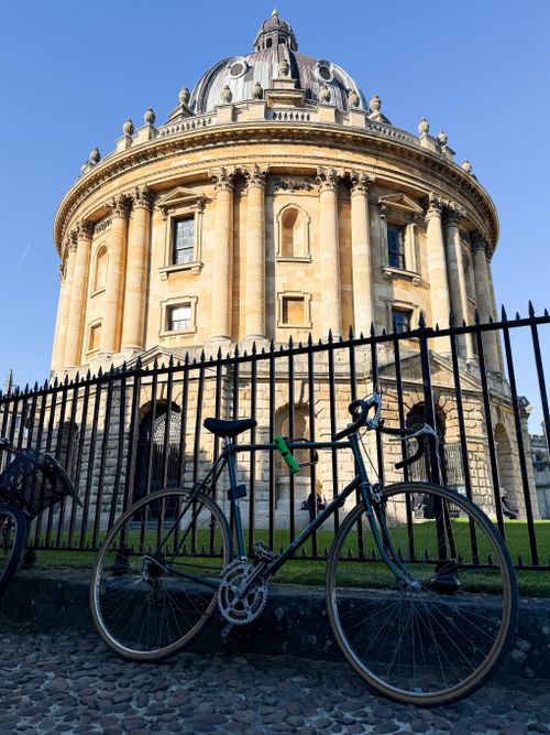 Free A bicycle parked at the historic Radcliffe Camera in Oxford, England, under a clear blue sky. Stock Photo