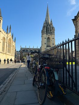 A sunny day in Oxford showcasing St. Mary's Church with bicycles lined up against a railing.