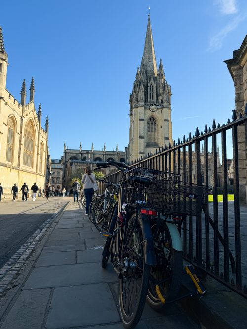 Free A sunny day in Oxford showcasing St. Mary's Church with bicycles lined up against a railing. Stock Photo