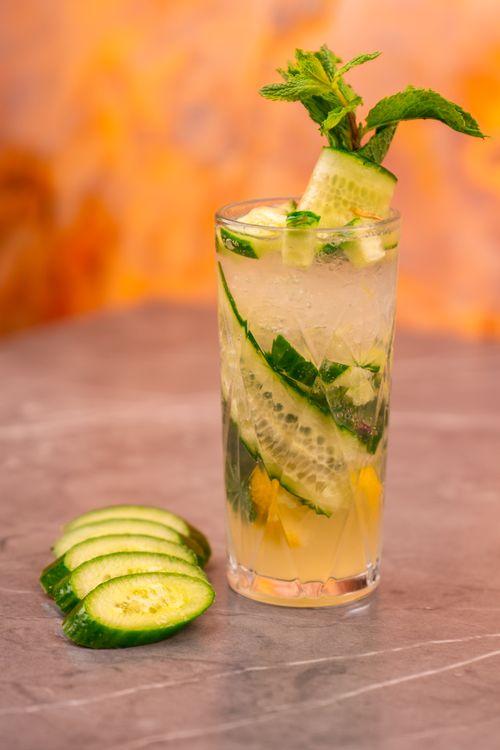 Free Chilled cucumber mint cocktail garnished with fresh herbs, perfect for summer. Stock Photo