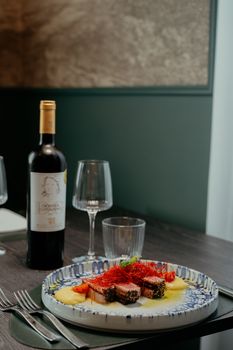 A delicious gourmet meal served with red wine at a cozy restaurant in Calabria, Italy.
