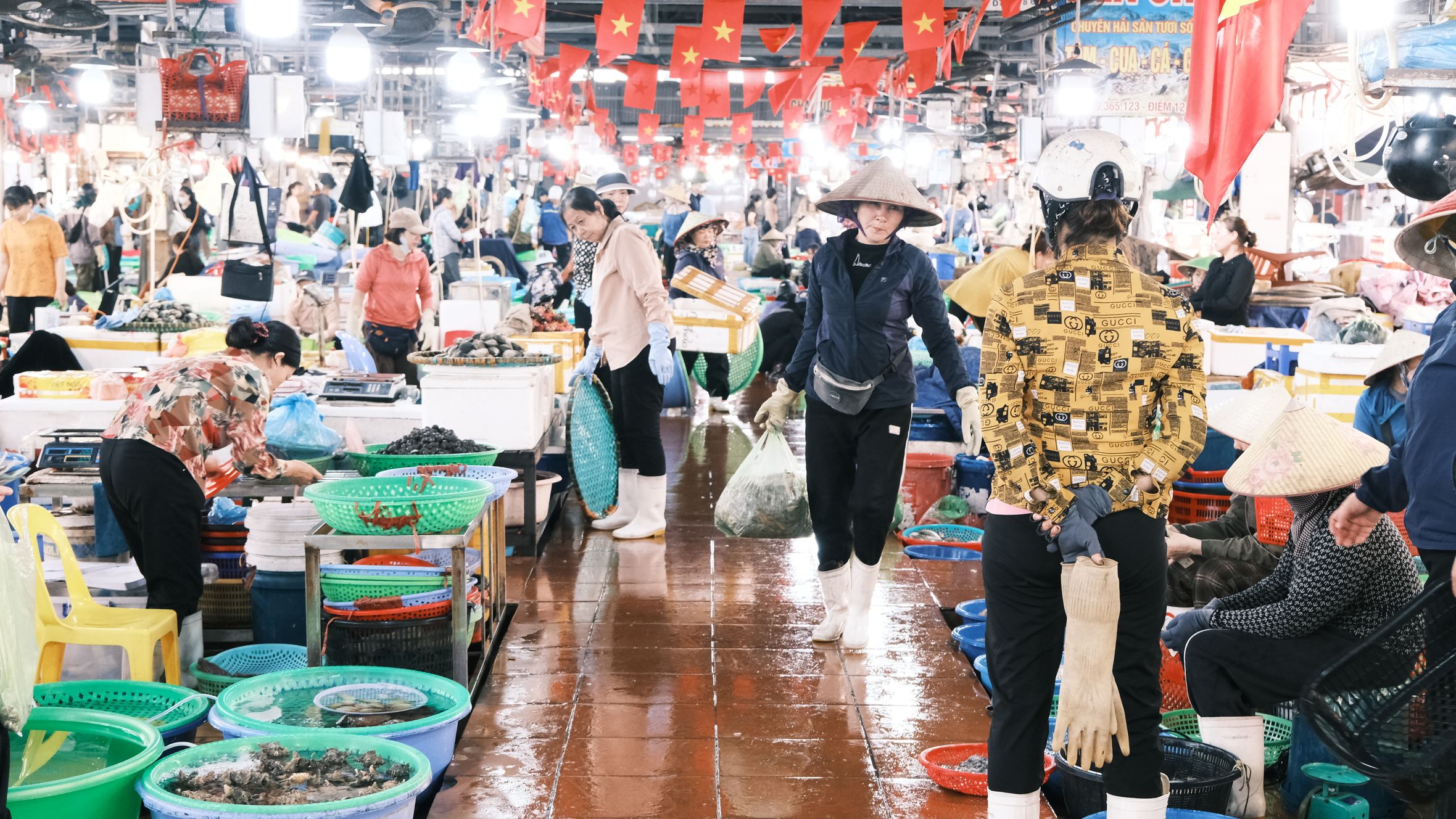 Vibrant indoor market bustling with vendors selling fresh produce in Vietnam.