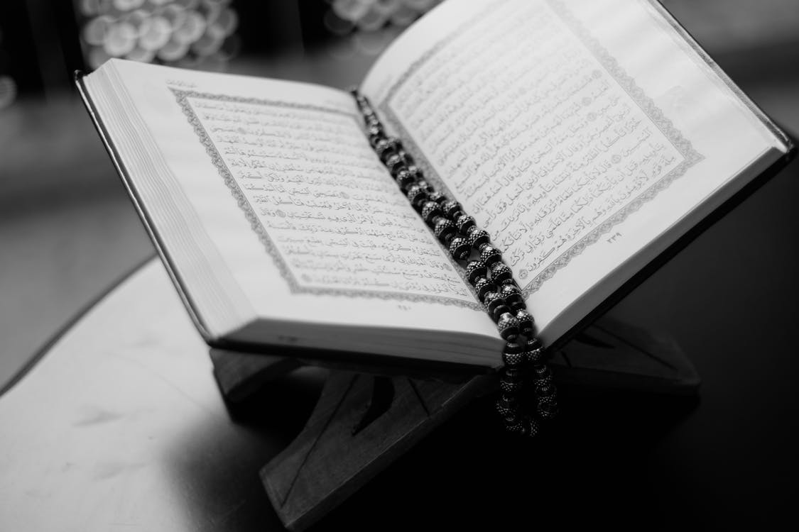 Grayscale Photo of Opened Qur'an