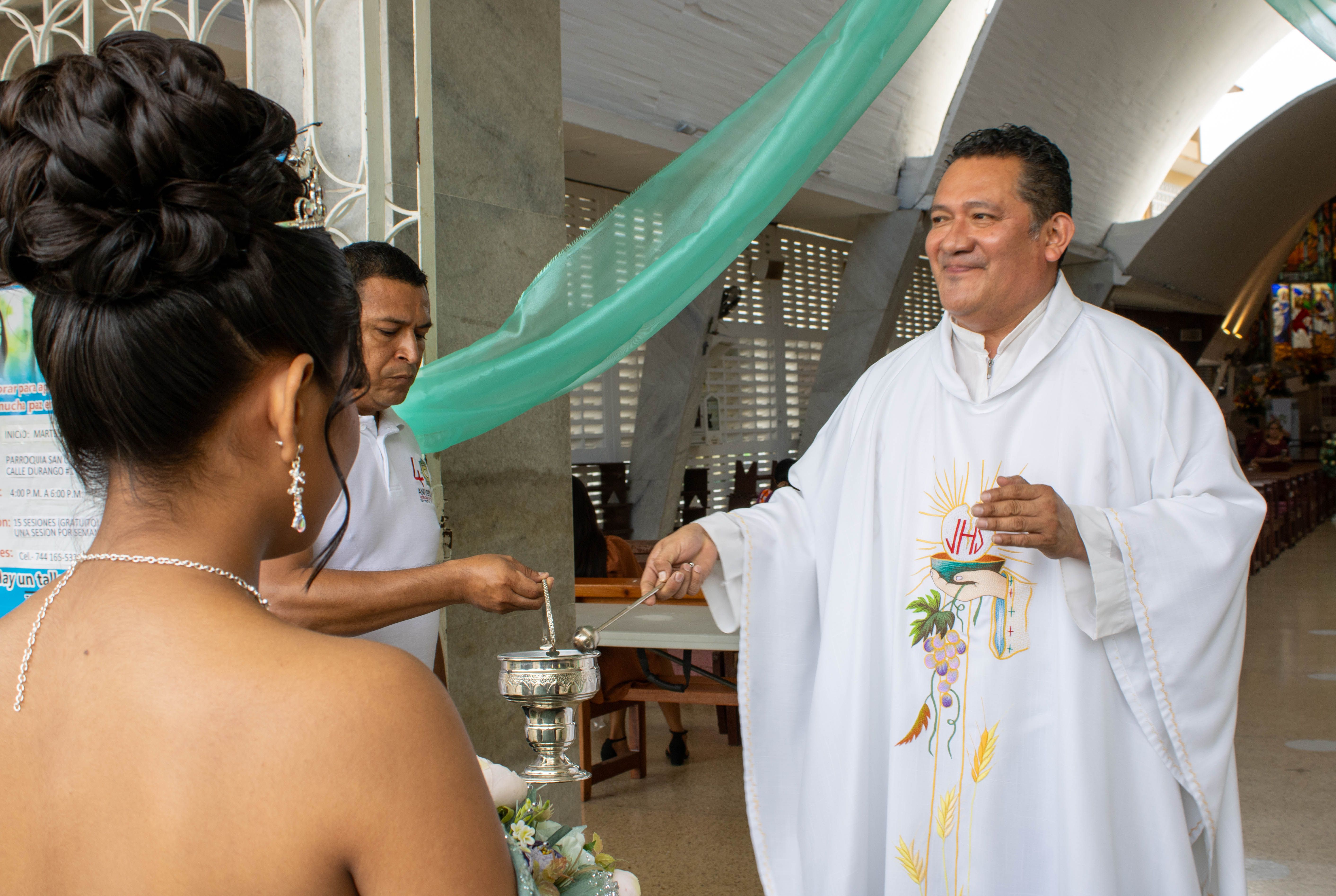 A priest performs a blessing ceremony inside a church in Acapulco, Mexico.