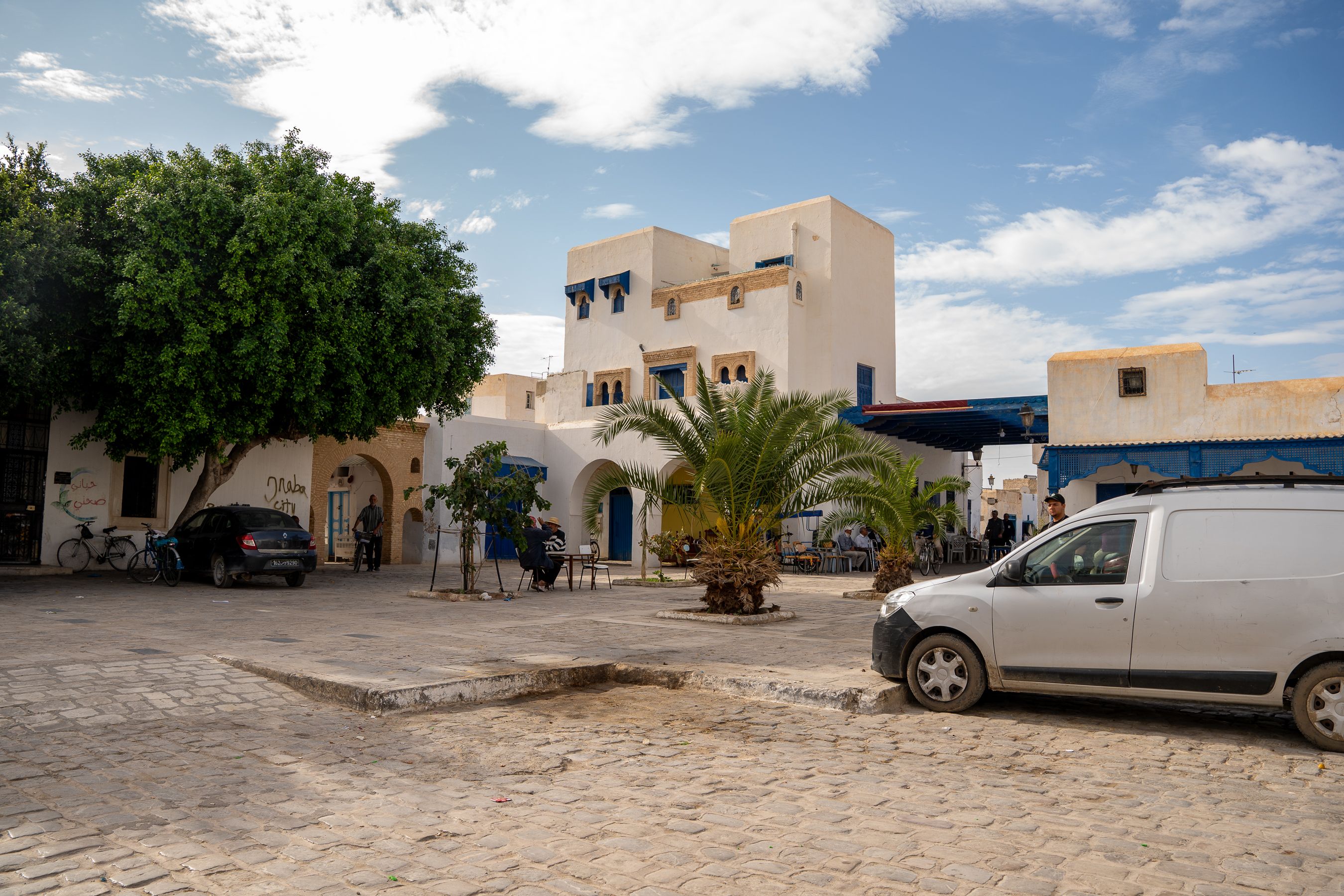 Quaint street scene in Djerba, Tunisia showcasing traditional architecture and daily life.