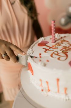 Close-up of birthday cake cutting with candle and decoration.
