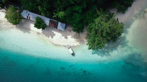Free Stunning aerial shot of a tropical beach in Southwest Papua, Indonesia, with clear turquoise waters and lush greenery. Stock Photo