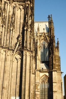 Historic Gothic architecture of Cologne Cathedral, bathed in golden sunlight, showcasing intricate details.