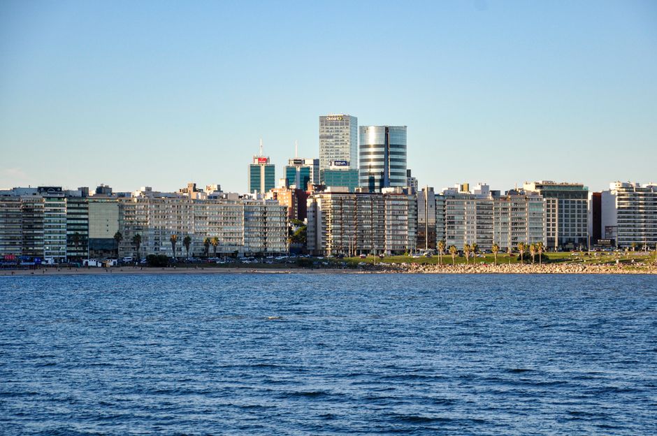 View of Montevideo's urban skyline from the waterfront against a clear blue sky.
