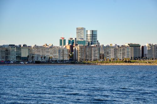 Free View of Montevideo's urban skyline from the waterfront against a clear blue sky. Stock Photo