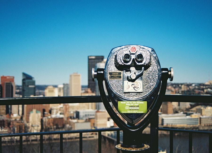 Coin-operated telescope with Pittsburgh skyline in background, stunning urban view.