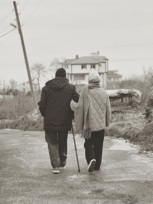 Free A senior couple walking together down a rural path in winter, creating a heartwarming scene. Stock Photo