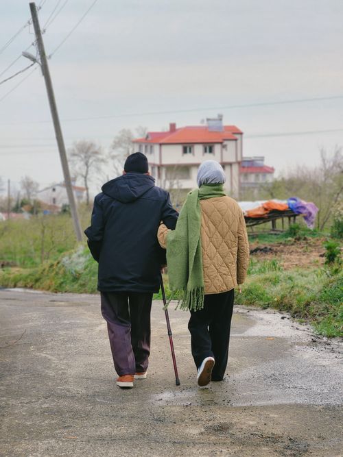 Free Elderly couple calmly walking on a rural road, showcasing companionship and tranquility. Stock Photo