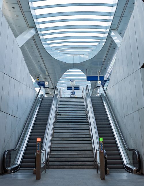 Free A sleek and modern train station interior featuring symmetrical escalators and contemporary design elements. Stock Photo