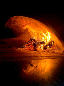 A wood-fired oven with glowing flames inside, creating a warm ambiance.
