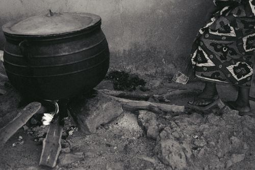 Free A traditional outdoor cooking setup in Jos, Nigeria with a cast iron pot and firewood. Stock Photo