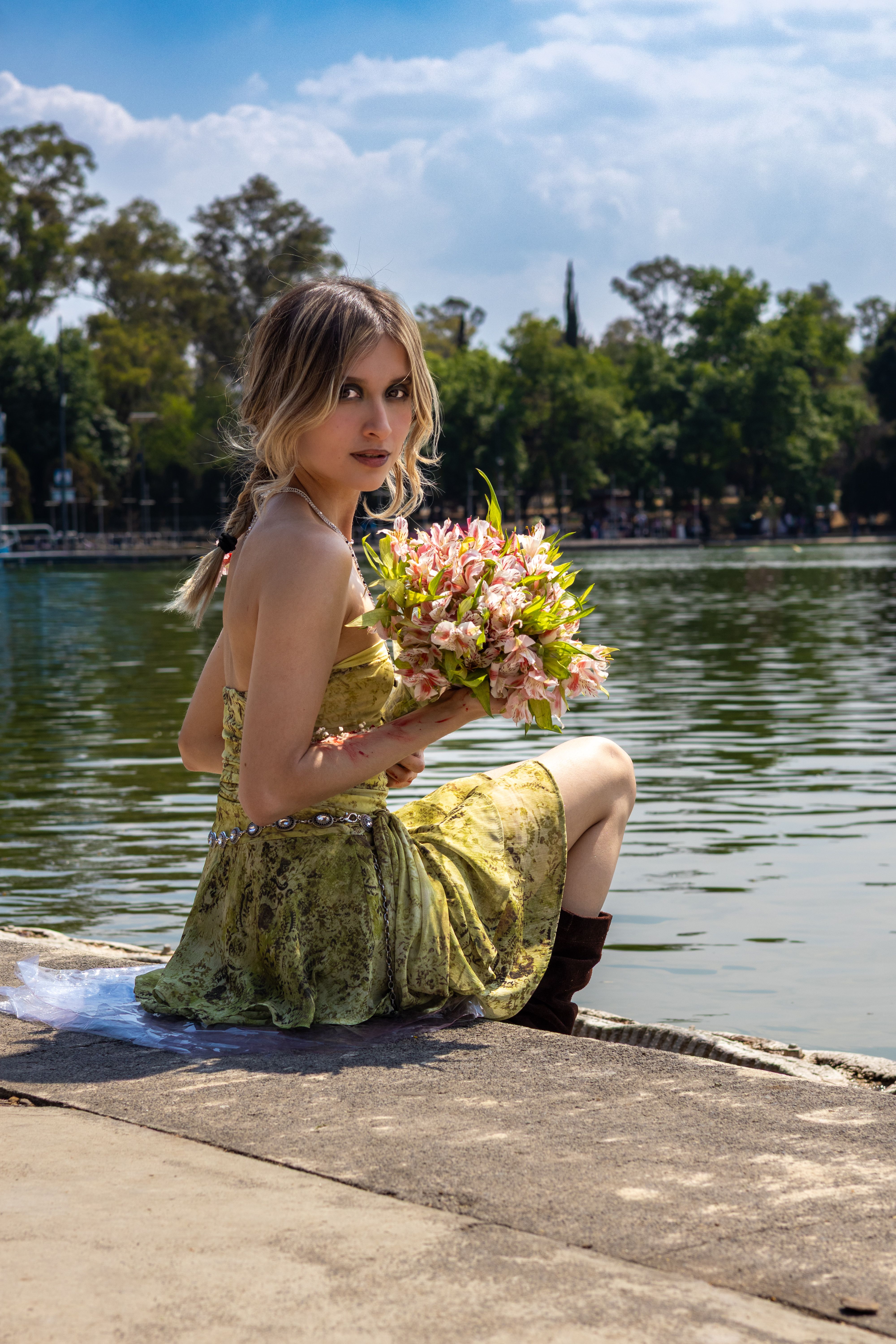 Woman by Lake Holding a Bouquet of Flowers · Free Stock Photo